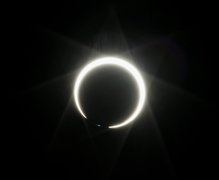 Photo of the eclipse with a bead of light in the bottom, illustrating the Baily's bead phenomenon.